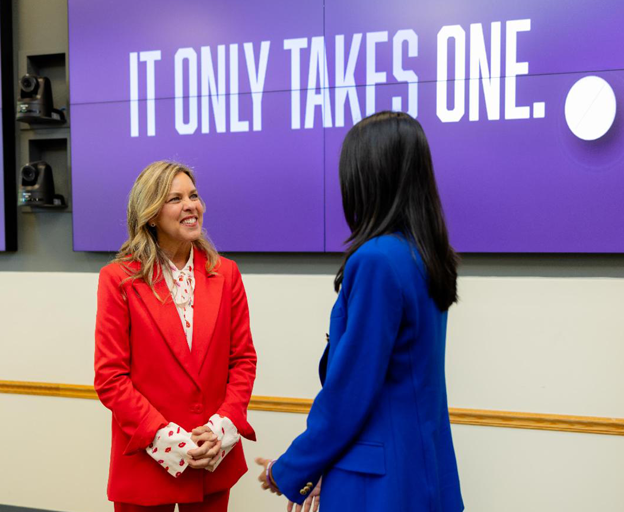 Première dame avec 2et personne debout devant la bannière de l'IOTO